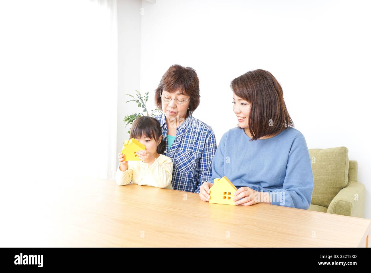 Trois générations trouvant une image de maison Banque D'Images