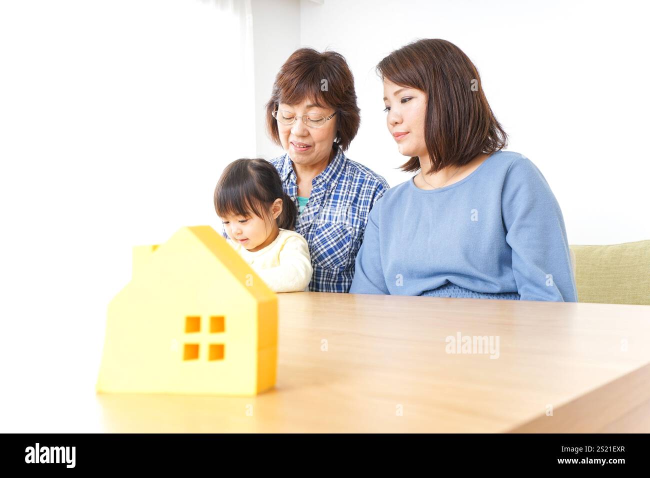 Trois générations trouvant une image de maison Banque D'Images