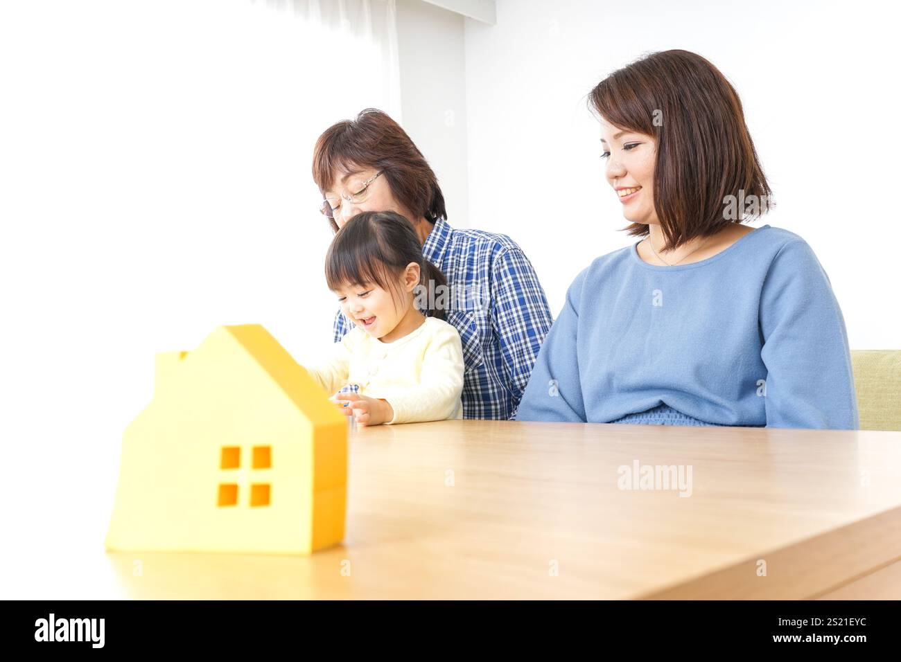 Trois générations trouvant une image de maison Banque D'Images