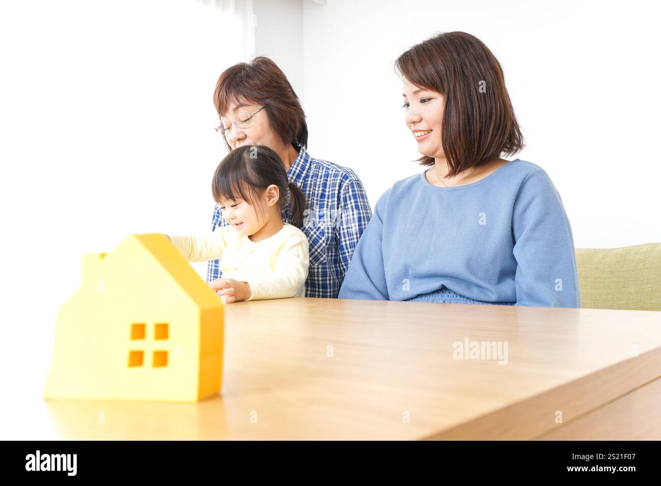 Trois générations trouvant une image de maison Banque D'Images