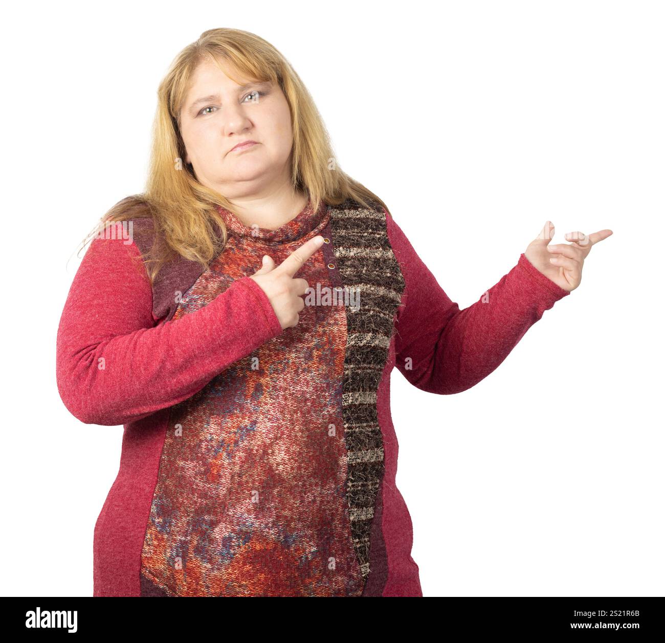 Une femme aux longs cheveux blonds pointe sur le côté avec les deux mains, affichant une posture confiante et affirmée. Banque D'Images