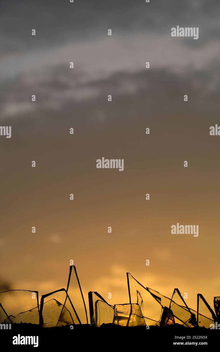 Coucher de soleil derrière le verre brisé. Banque D'Images