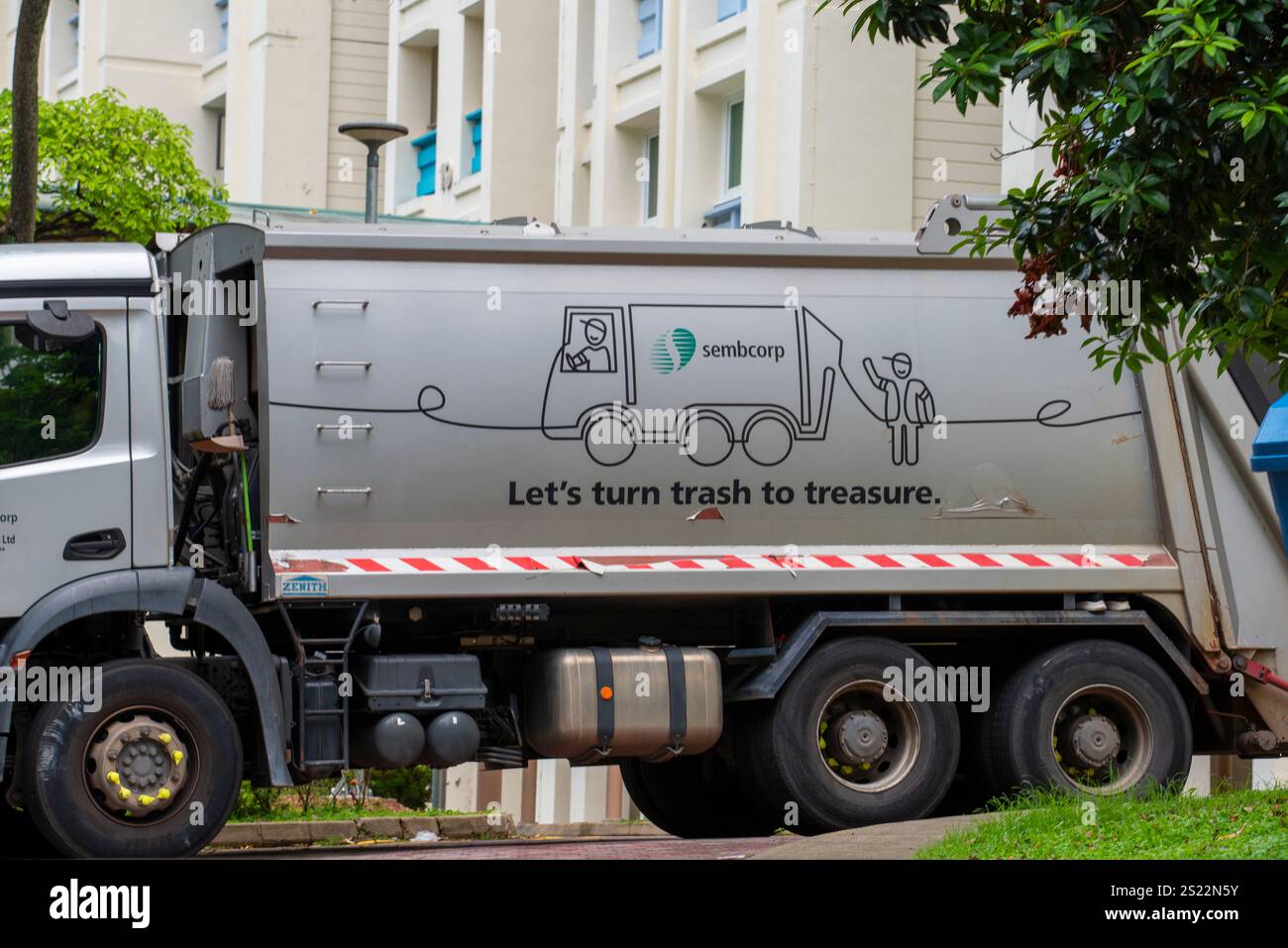 Un panneau de message environnemental positif sur le côté d'un camion à ordures à chargement arrière à Singapour Banque D'Images