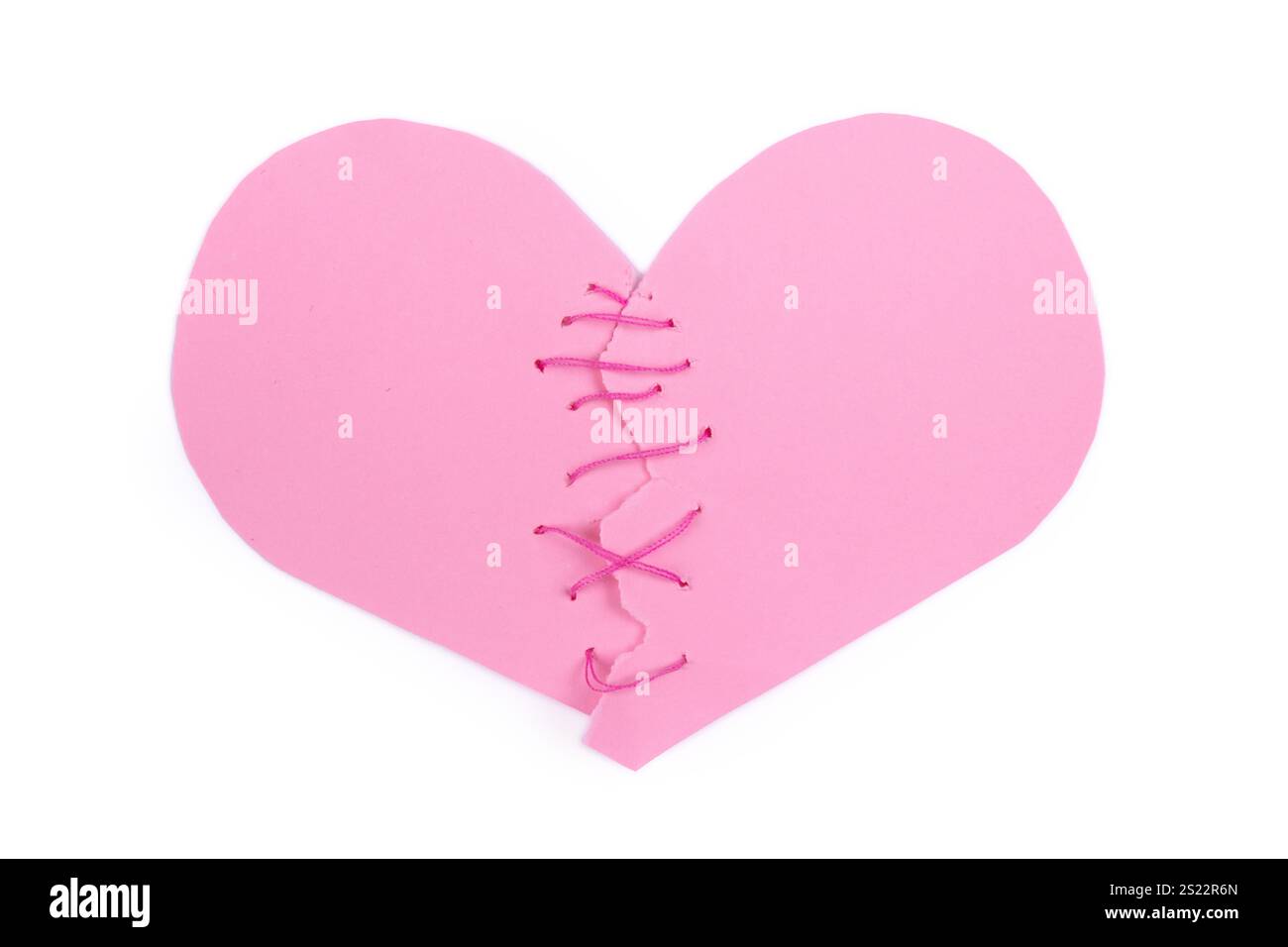 Coeur déchiré en demi-papier cousu avec des fils roses isolé sur fond blanc Banque D'Images