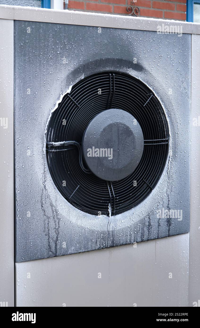 Unité de pompe à chaleur HVAC dans une zone extérieure résidentielle, présentant la technologie de l'énergie durable pour un chauffage efficace en hiver. Banque D'Images