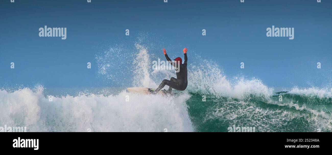 Image panoramique d'un surfeur qui fait une vague à Fistral à Newquay, en Cornouailles, au Royaume-Uni. Banque D'Images