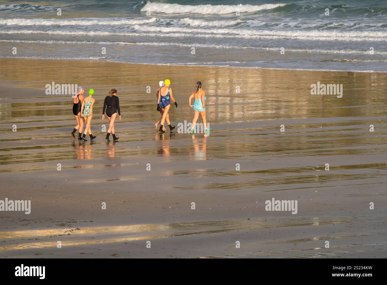 Un groupe de femmes nageuses d'eau froide marchant vers la mer pour une baignade tôt le matin à Towan Beach à Newquay Cornwall Royaume-Uni. Banque D'Images