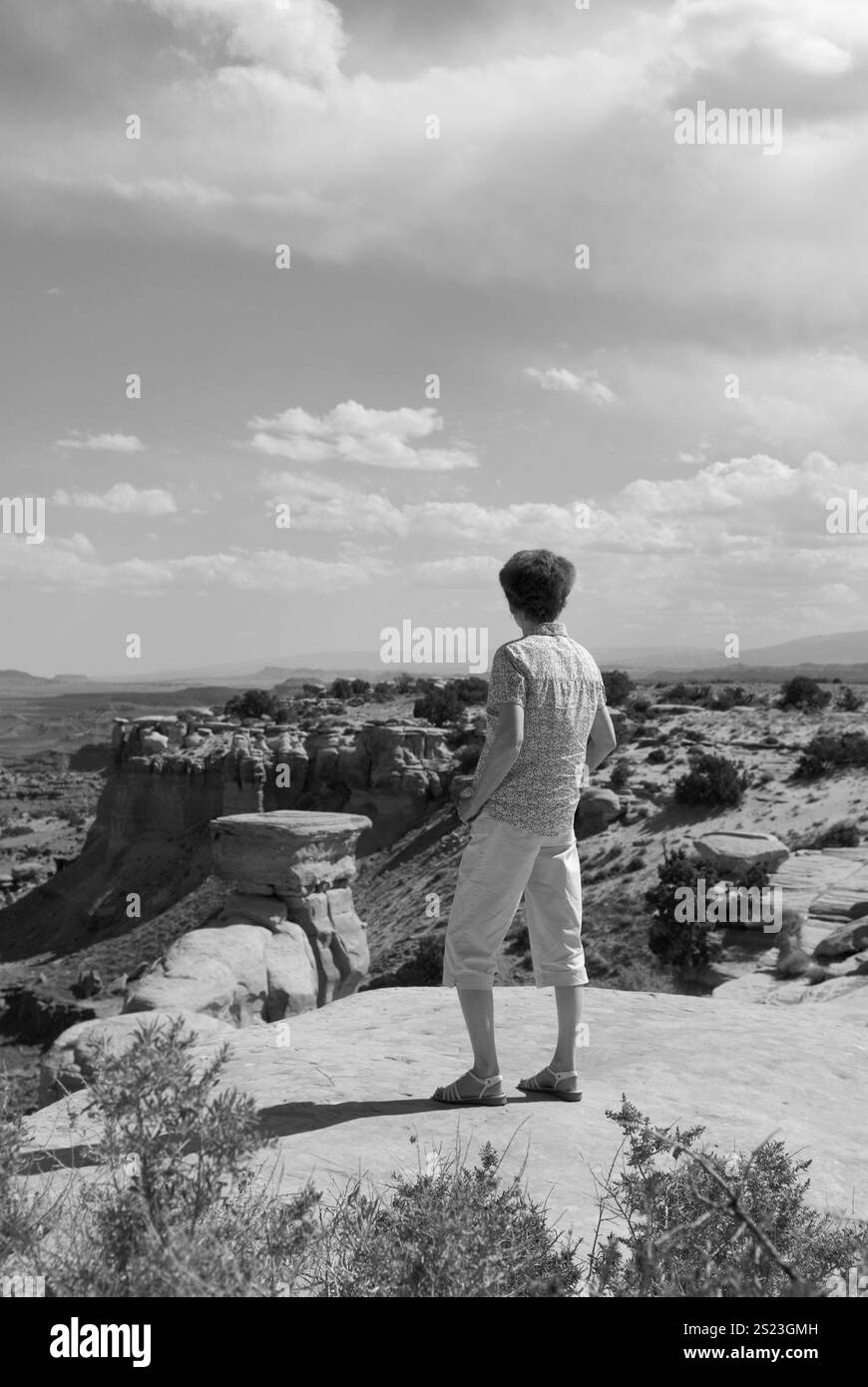 Femme âgée caucasienne profitant de la vue imprenable sur la houle de San Rafael dans l'Utah, aux États-Unis, un arrêt populaire pour les voyageurs explorant la beauté sauvage de l'UT. Banque D'Images