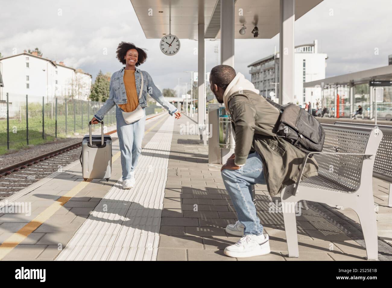 Heureux jeune couple afro-américain serrant dans ses bras à une gare, se réunissant après un long voyage. Concepts de voyage, d'accueil et d'amour. Banque D'Images