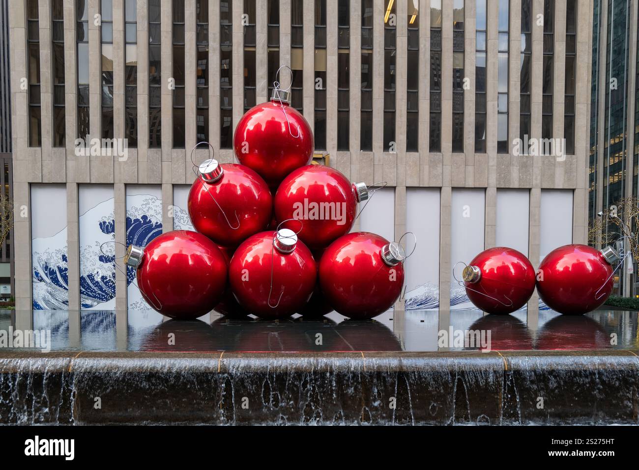 Une fontaine à New York est décorée de boules géantes de sapin de Noël rouges Banque D'Images