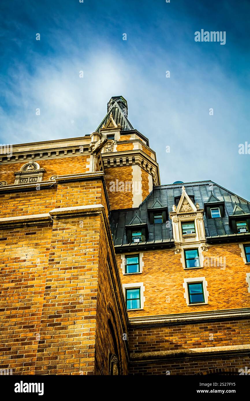 Un bâtiment en briques avec un clocher et un toit bleu. Le bâtiment est grand et a beaucoup de fenêtres Banque D'Images