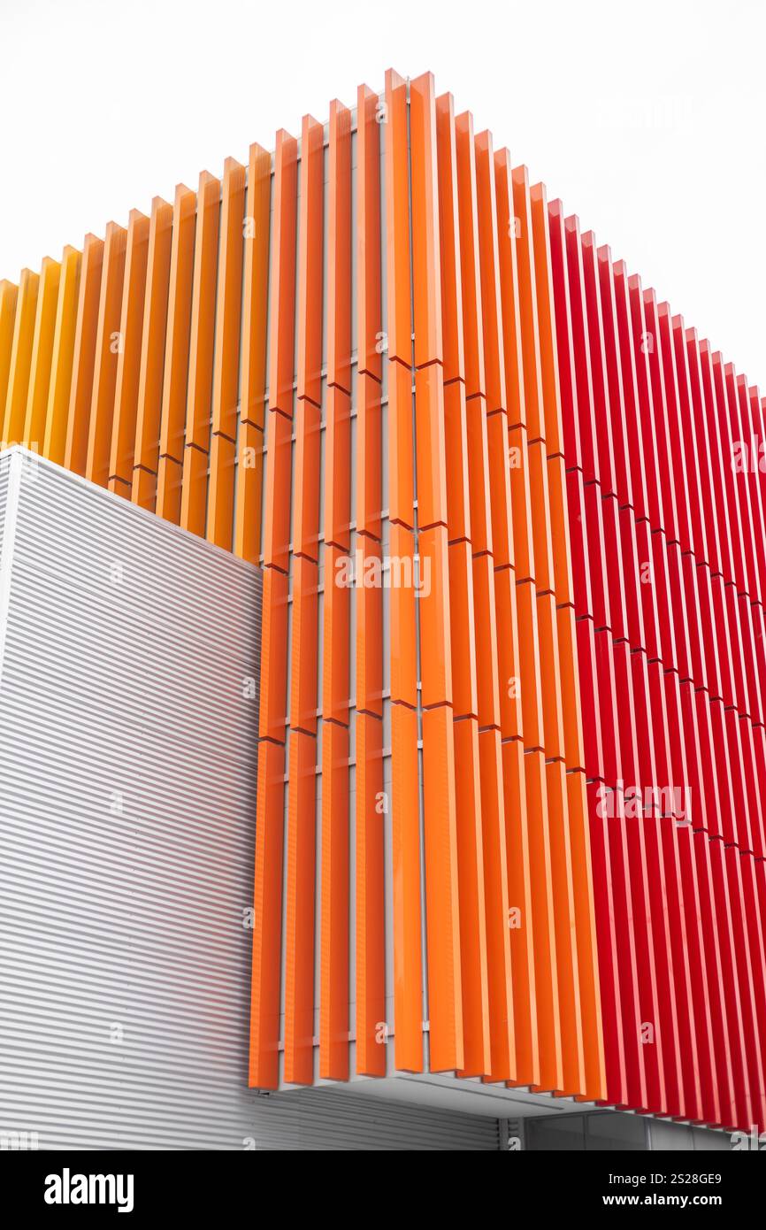 Un mur minimaliste avec des motifs rouges et oranges vibrants. Les couleurs audacieuses créent un contraste visuel saisissant, ajoutant de l'énergie et une touche moderne à l'espace, Banque D'Images