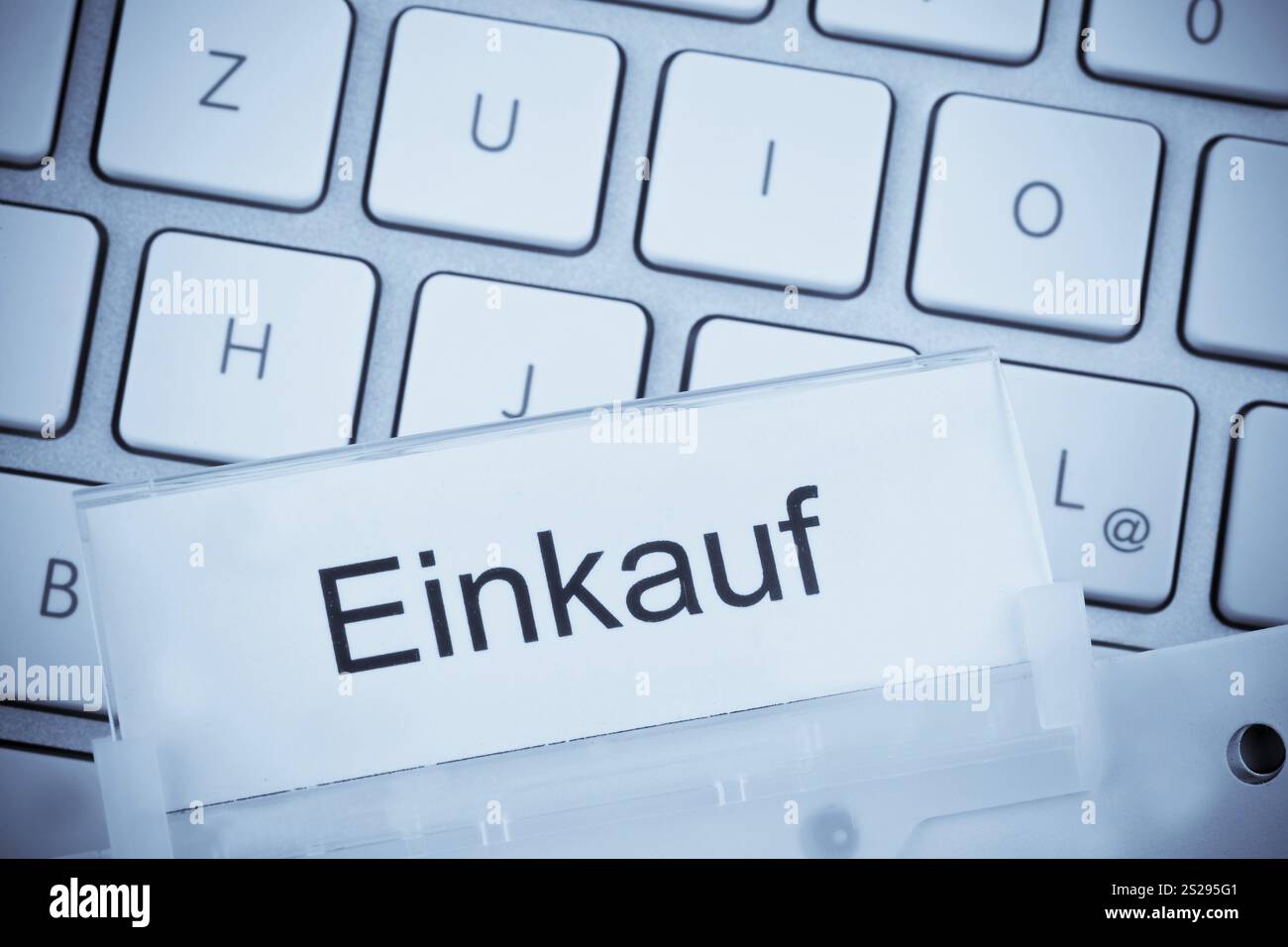 Un dossier pour les dossiers dans un dossier suspendu devant un clavier d'ordinateur sur le sujet : acheter l'Autriche Banque D'Images