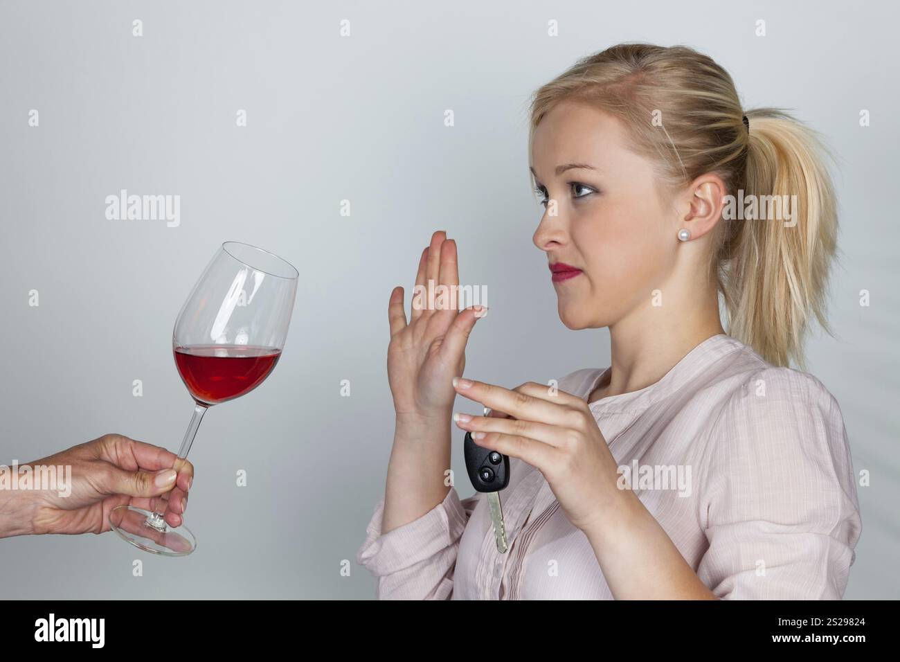 Une jeune femme avec des clés de voiture refuse un verre de vin. Ne conduisez pas en buvant Banque D'Images