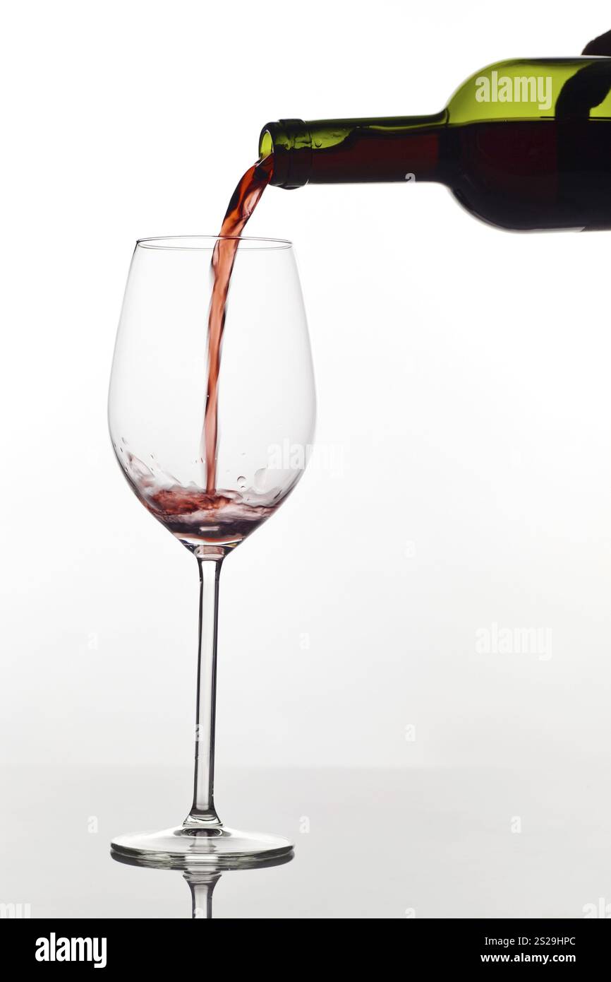 Le vin rouge est versé dans un verre avec une fleur. Vin rouge dans un verre de vin rouge Autriche Banque D'Images
