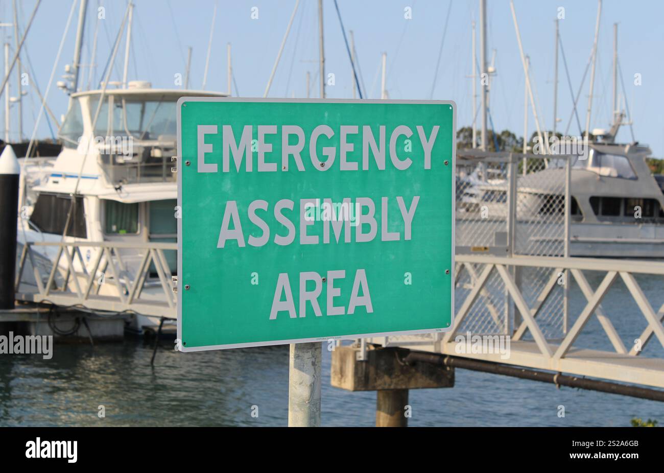 Panneau « zone de rassemblement d'urgence » dans une marina avec bateaux Banque D'Images Panneau « zone de rassemblement d'urgence » dans une marina avec bateaux Banque D'Images