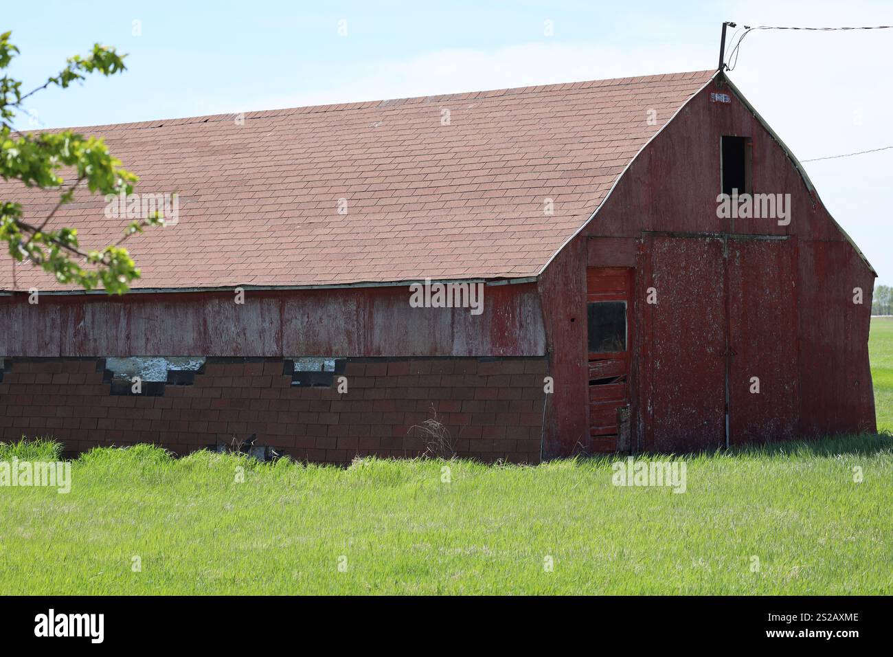 grange abandonnée délabrée avec une peinture rouge classique décolorée Banque D'Images
