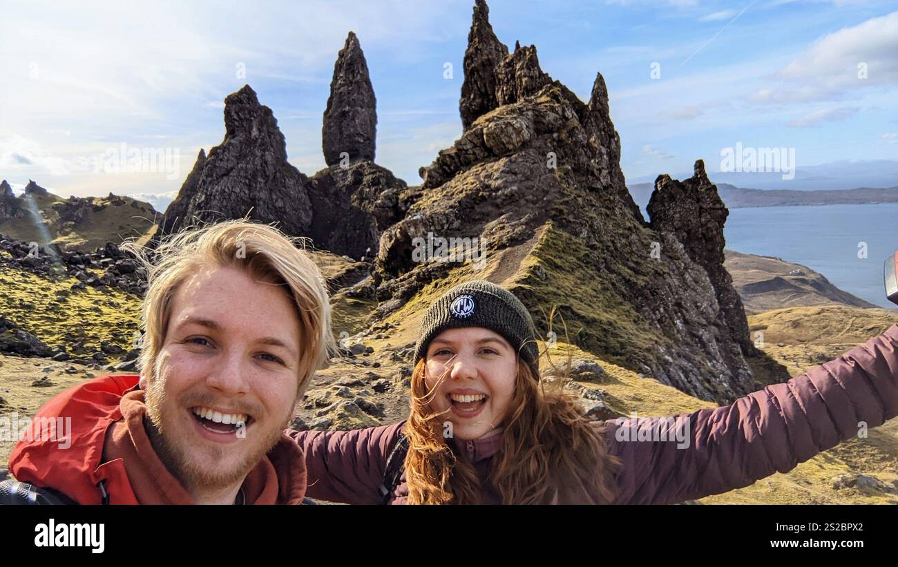 2 personnes souriantes excitées à côté du vieil homme de Storr sur l'île de Skye Banque D'Images