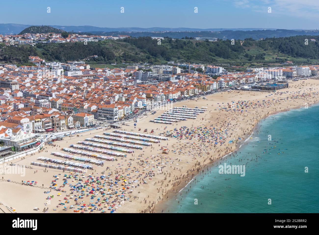 Nazaré plage de sable, boulevard et océan Atlantique sur une journée d'été avec une plage pleine de gens à Nazare Portugal. Banque D'Images