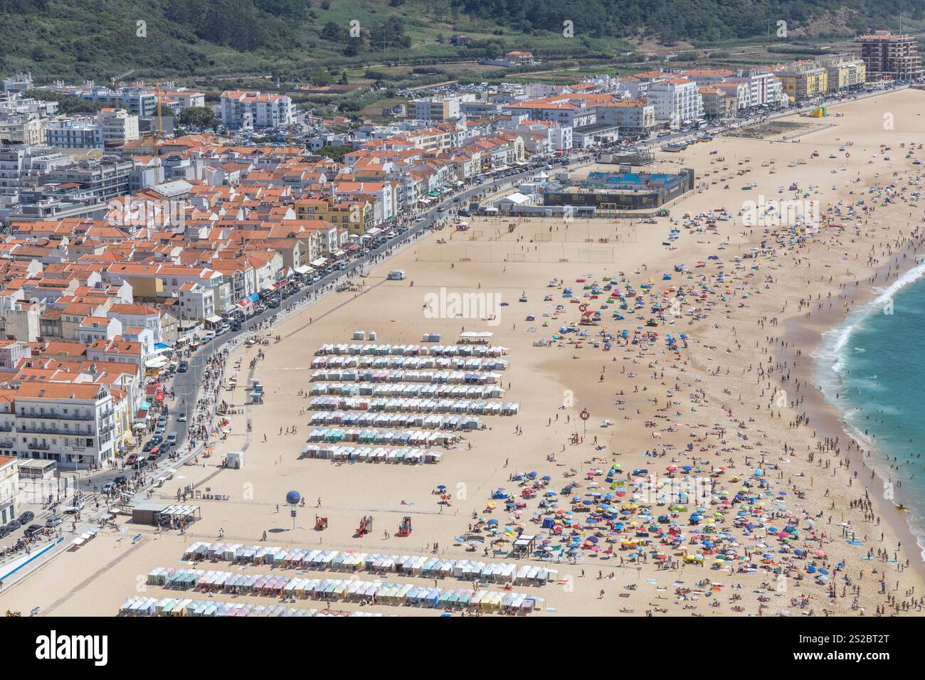 Nazaré plage de sable et boulevard un jour d'été avec une plage pleine de gens à Nazare Portugal. Banque D'Images