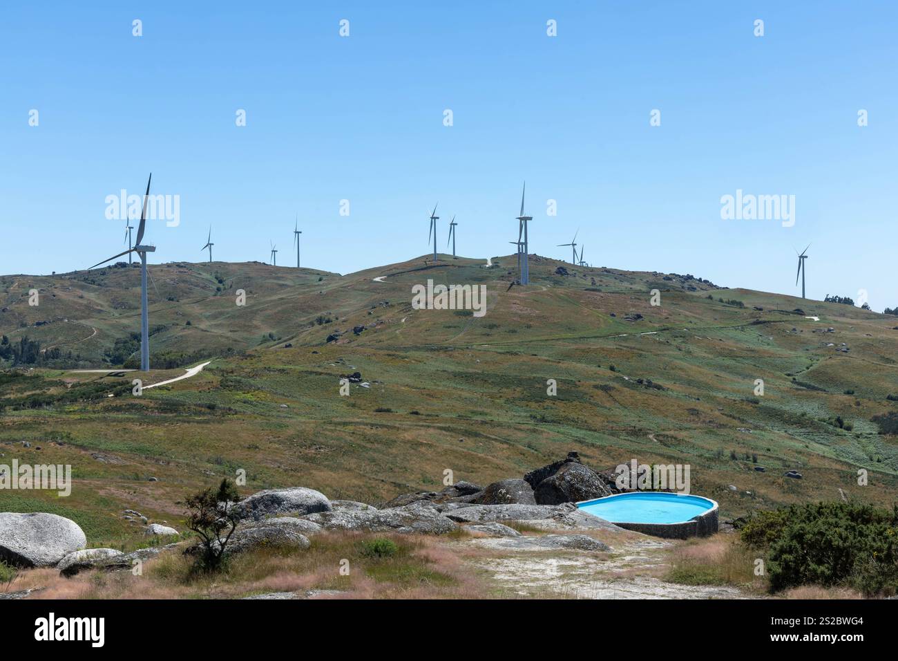 Éolienne concept d'énergie renouvelable écologique sur les montagnes portugaises avec une piscine dans la forground. Banque D'Images