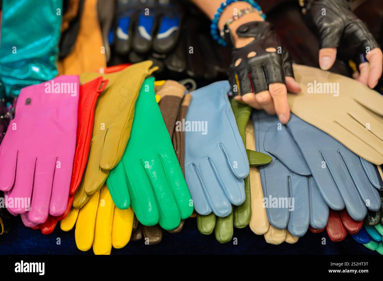 Beaucoup de gants de femmes colorés différents sur le comptoir, les mains du vendeur Banque D'Images