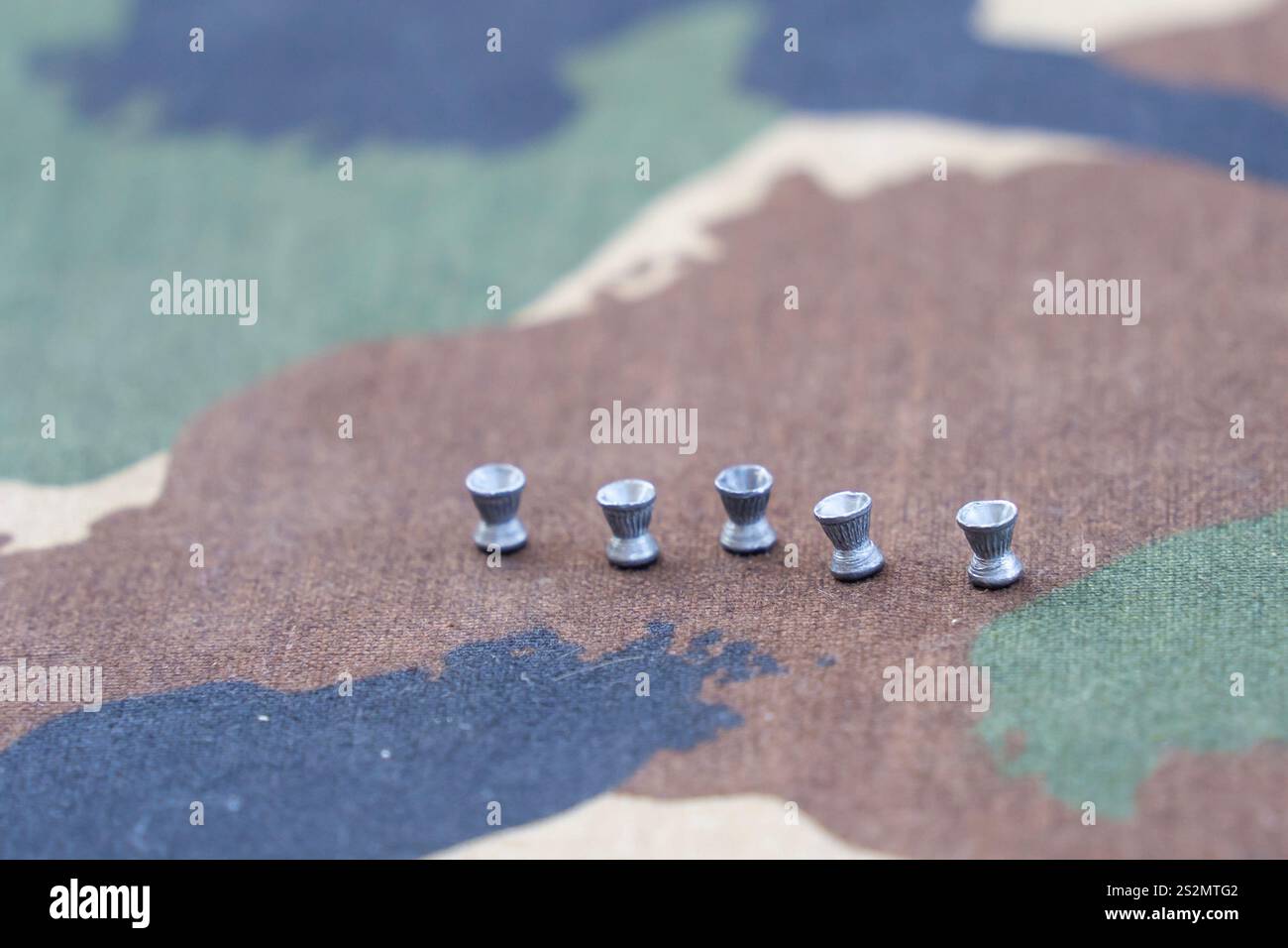 Munition de fusil à air comprimé sur une table de camouflage Banque D'Images