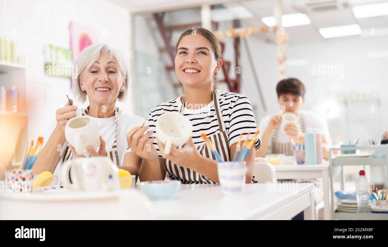 Gaies vieilles et jeunes tasses de peinture wowen dans la masterclass de poterie Banque D'Images