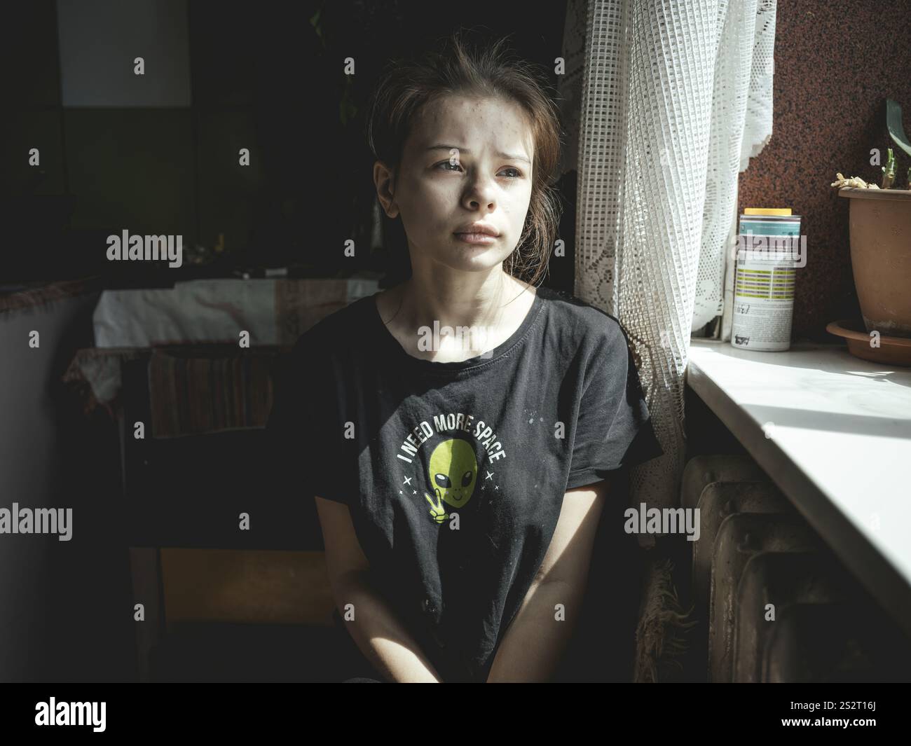 Alina, 15 ans, dans la cuisine de l'appartement où elle vit avec ses frères et sœurs, sa mère et son beau-père. Ukrainsk est très proche du front Banque D'Images