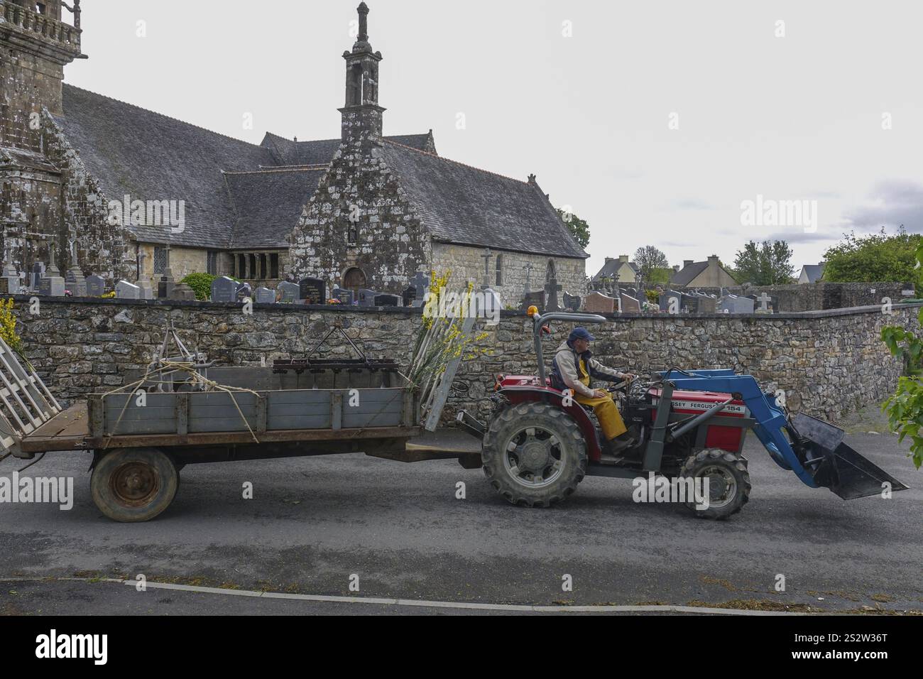 Vieux tracteur Massey Ferguson 154 avec remorque devant l'église et la chapelle Sainte nonne, voiture ancienne rencontre Dirinon, département Finistère Penn Ar Bed Banque D'Images