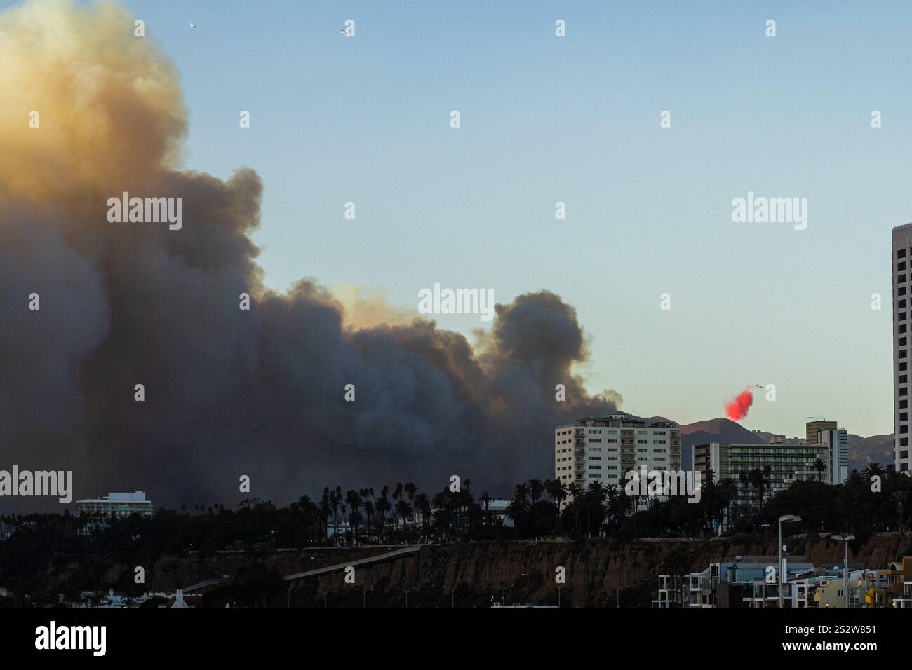 Los Angeles, États-Unis. 7 janvier 2025. Un avion de lutte contre les incendies lâche un ignifuge rouge alors que le feu des Pacific Palisades brûle près de Los Angeles, en Californie. Des vents violents et des conditions sèches devraient intensifier les feux de forêt dans les Palisades du Pacifique. Crédit : Stu Gray/Alamy Live News. Banque D'Images