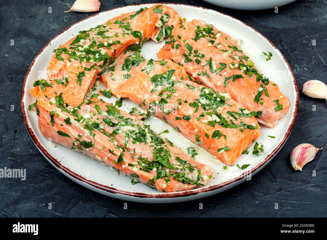 Filet de saumon frais cru dans une marinade verte à l'ail prêt à être cuit. Gravlax. Banque D'Images