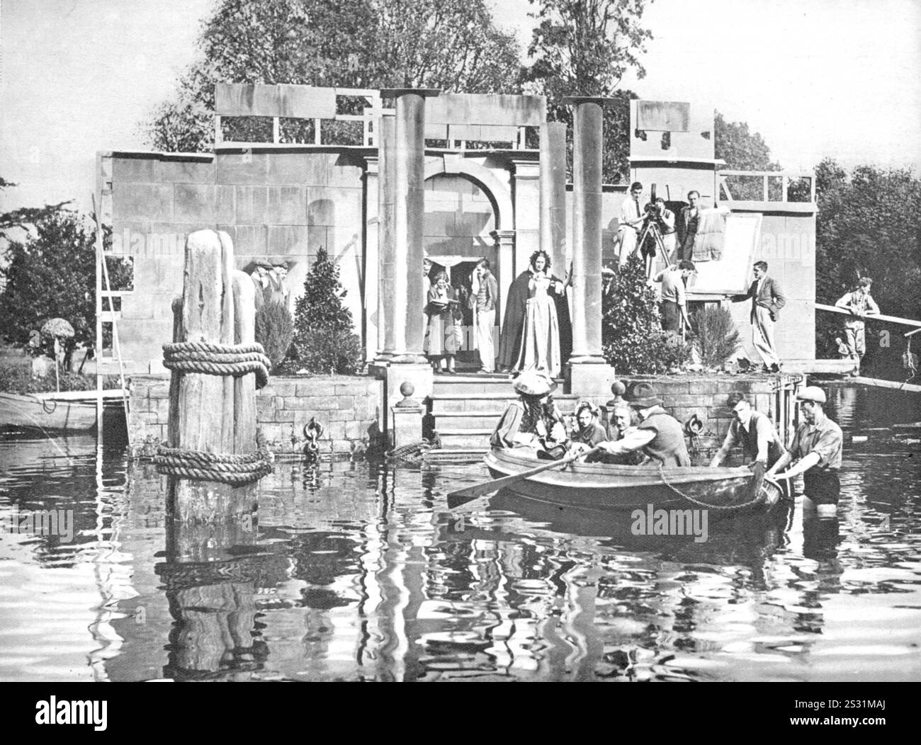 Capitaine Blood. Production tournée aux studios Sound City, Shepperton, pendant le tournage du colonel Blood. La Tamise est le lac ornemental dans le parc du studio, l'ensemble représente une petite section du quai de Whitehall au 17ème siècle construit par le studio à partir de vieilles estampes. Dans la poupe du bateau est Arthur Chesney comme Samuel Pepys et à gauche du rameur est Frank Cellier. La caméra date : 1935 Banque D'Images Capitaine Blood. Production tournée aux studios Sound City, Shepperton, pendant le tournage du colonel Blood. La Tamise est le lac ornemental dans le parc du studio, l'ensemble représente une petite section du quai de Whitehall au 17ème siècle construit par le studio à partir de vieilles estampes. Dans la poupe du bateau est Arthur Chesney comme Samuel Pepys et à gauche du rameur est Frank Cellier. La caméra date : 1935 Banque D'Images