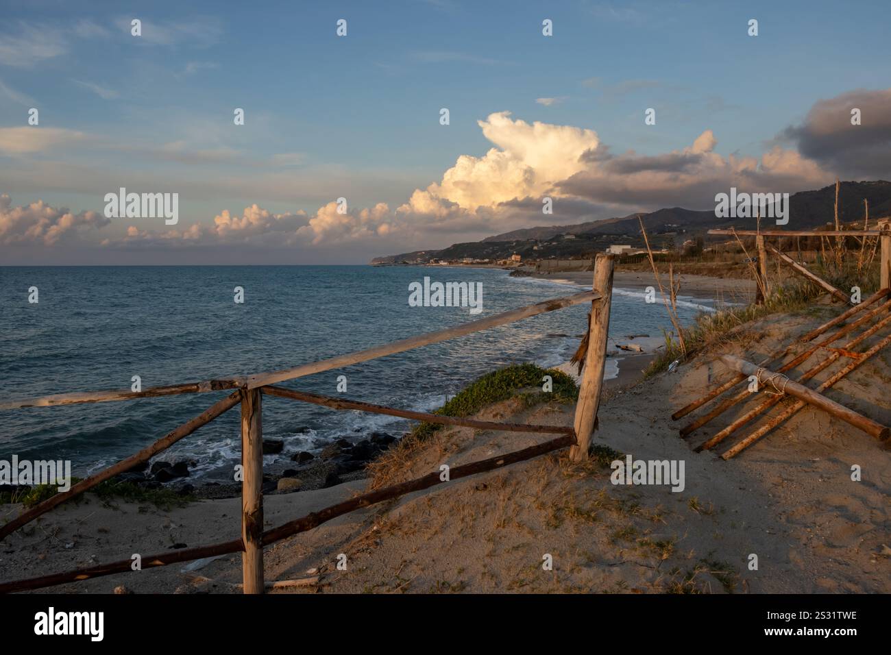 Soirée à la plage de sable au moment du coucher du soleil. Calme mer Tyrrhénienne (Méditerranée). Nuage lumineux enligé par la lumière du soleil. Torregrotta, Sicile, I. Banque D'Images