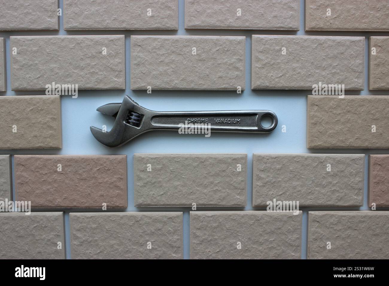 Clé réglable dans le compartiment à l'intérieur des carreaux briques vue de dessus. Photo stock pour illustration de réparation DIY Banque D'Images