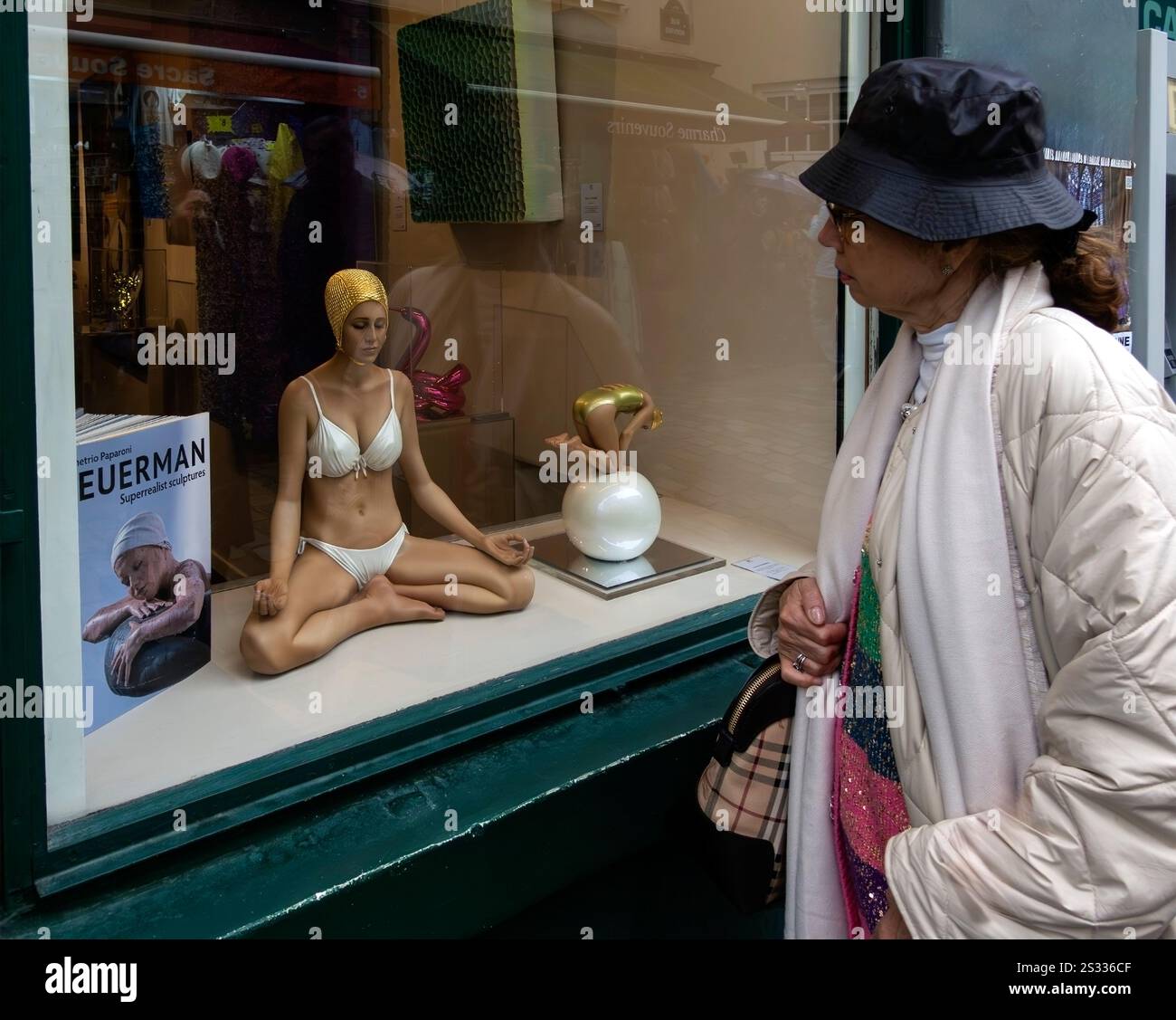 Femme regarde dans la fenêtre de la galerie d'art à Montmartre, Paris, France à une sculpture superréaliste de Carole Feuerman Banque D'Images