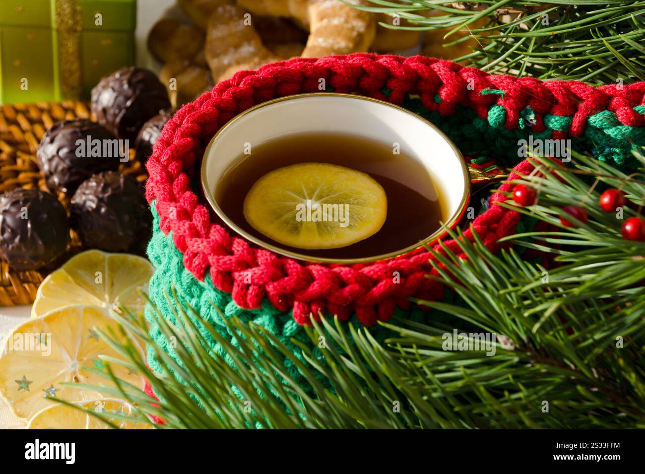Tasse de thé au citron. Chocolats, citron séché et branches d'arbre de Noël. Carte de vacances. Banque D'Images
