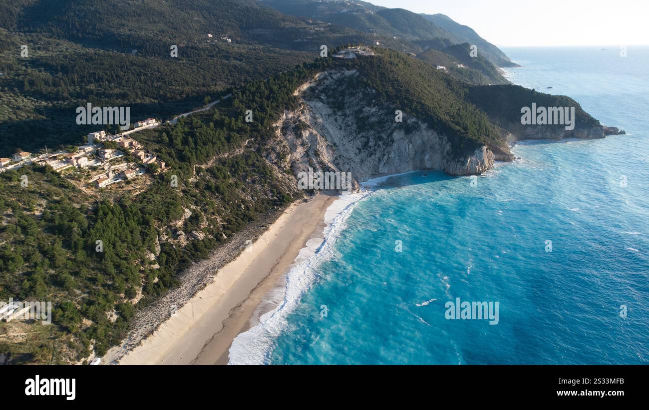 Une vue aérienne panoramique capture une plage magnifique avec des montagnes pittoresques s'élevant majestueusement en arrière-plan, le long d'une grande étendue d'eau Banque D'Images