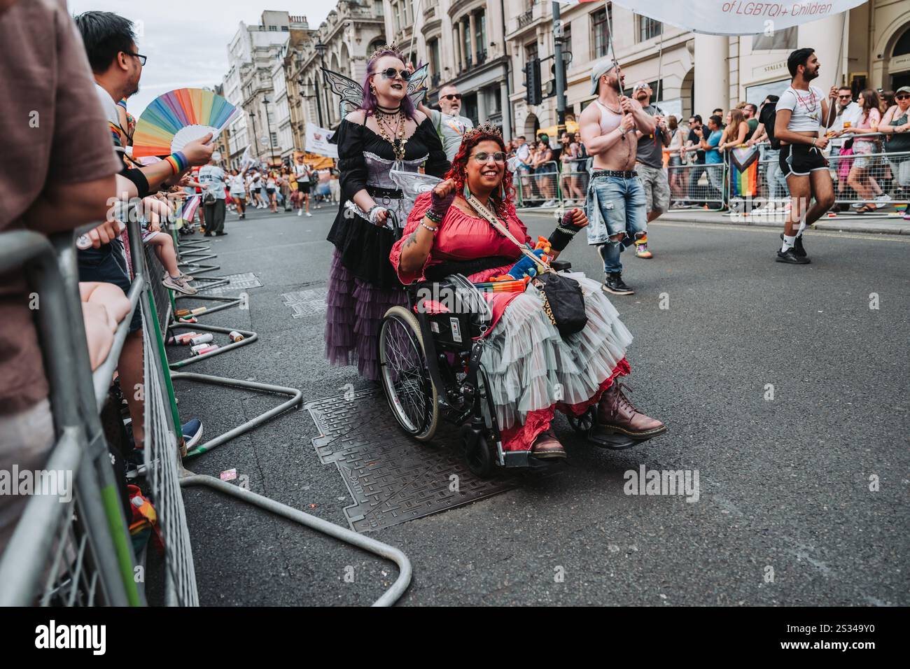 Divers participants célébrant Pride Parade en costumes festifs et en fauteuil roulant Banque D'Images