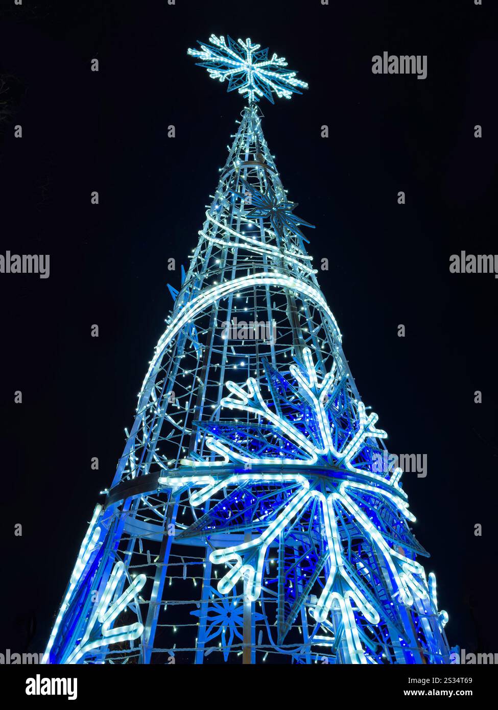 Sapin de Noël illuminé la nuit avec des lumières LED bleues et de grandes décorations de flocon de neige, créant une atmosphère festive de vacances Hanley Stoke on Trent Banque D'Images