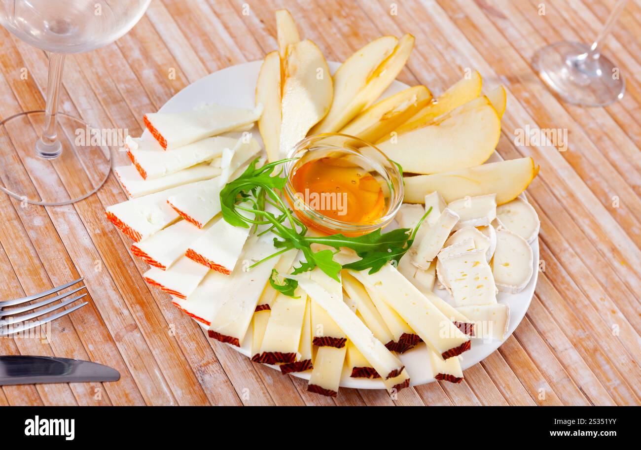 Différents types de fromage et de tranches de poire sur l'assiette Banque D'Images