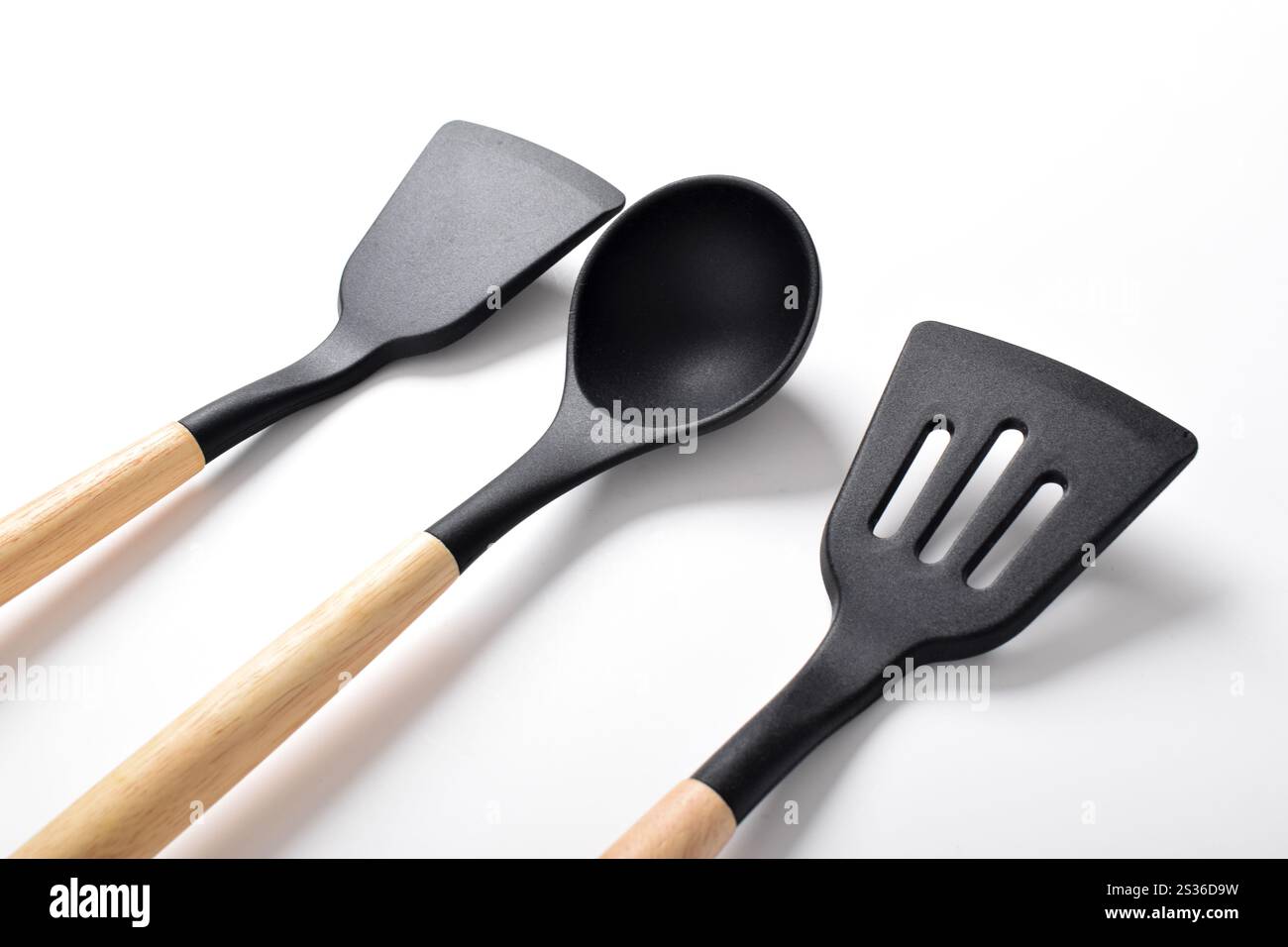 Ustensiles de cuisine en silicone avec manche en bois isolé sur fond blanc. Ensembles d'ustensiles de cuisine Banque D'Images