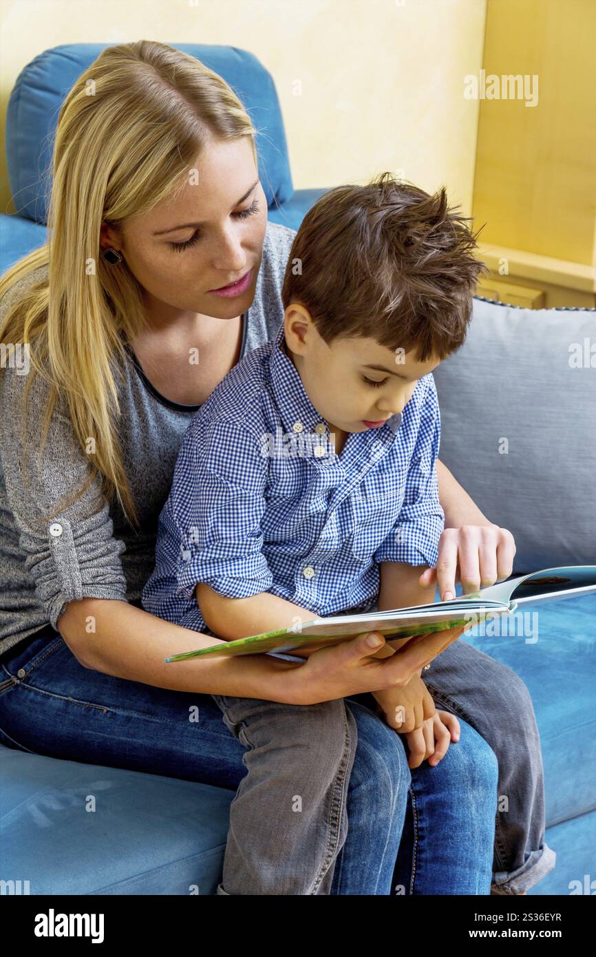 Mère et fils avec un livre, symbolisant l'amour maternel, la famille, l'apprentissage Banque D'Images
