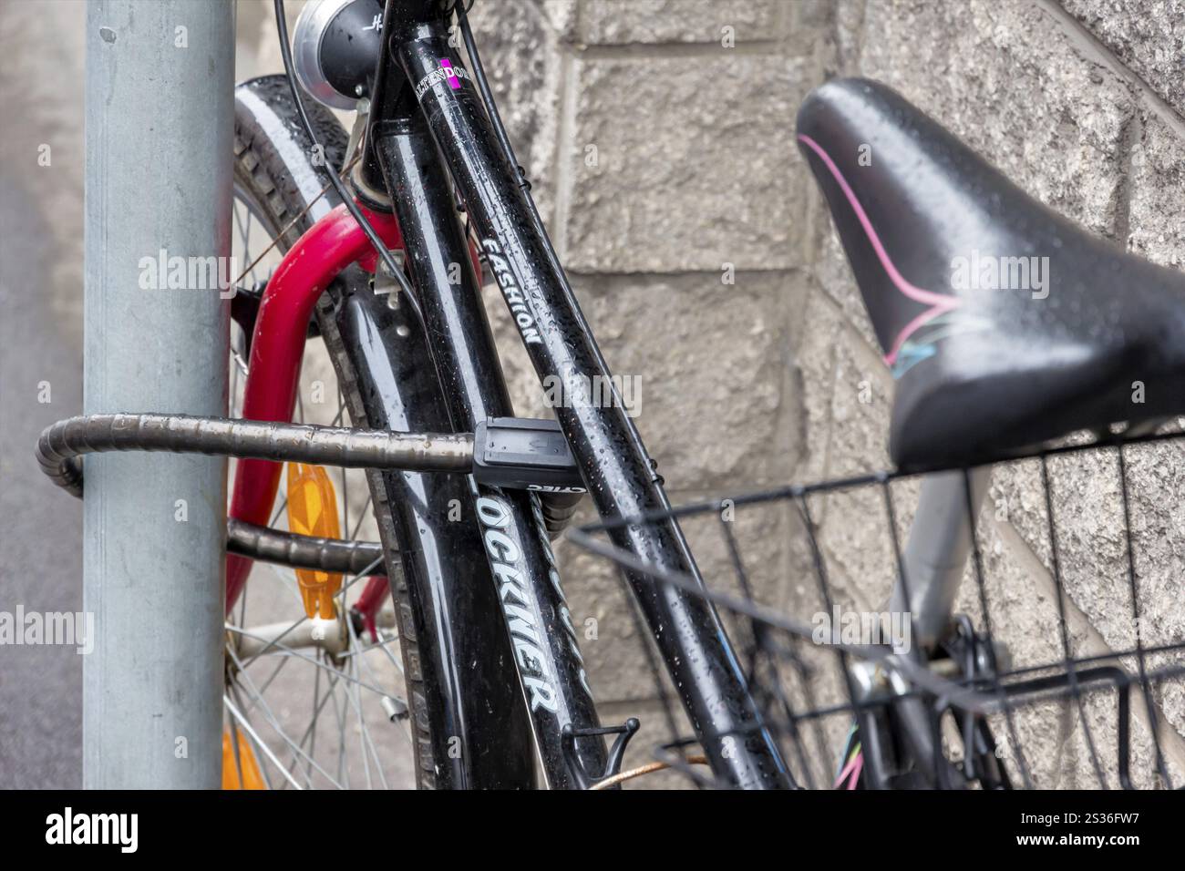Une bicyclette était fixée à un poteau pour la protéger contre le vol. Serrure de bicyclette comme dispositif antivol Autriche Banque D'Images