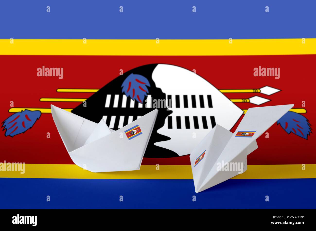 Drapeau du Swaziland représenté sur un avion et un bateau en origami en papier. Concept d'arts orientaux faits à la main. Drapeau du Swaziland représenté sur un avion origami en papier et Banque D'Images