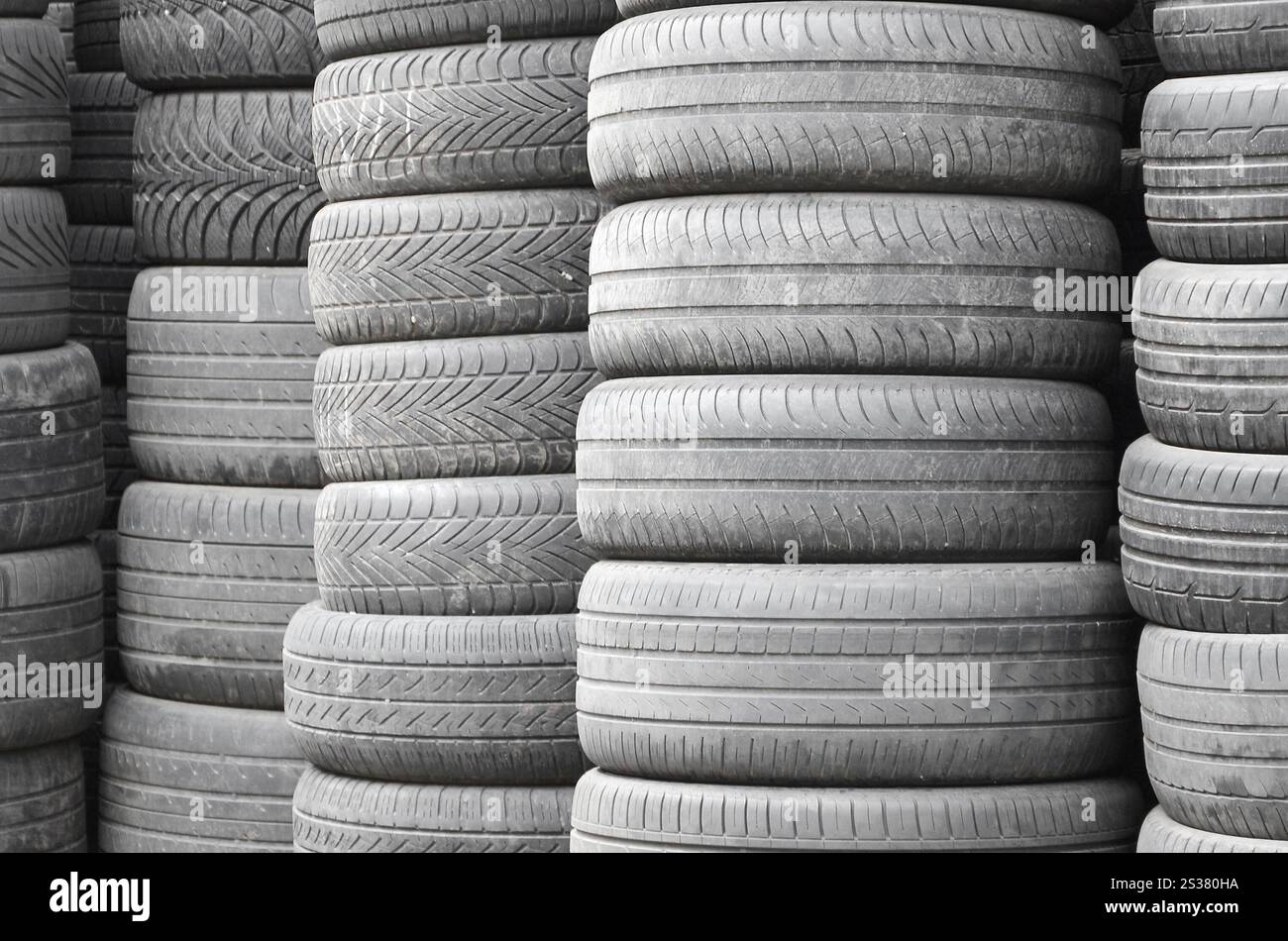 Vieux pneus usagés empilés avec des piles élevées dans le garage secondaire de magasin de pièces de voiture de près. Vieux pneus usagés empilés avec des piles élevées dans des pièces de voiture secondaires Banque D'Images