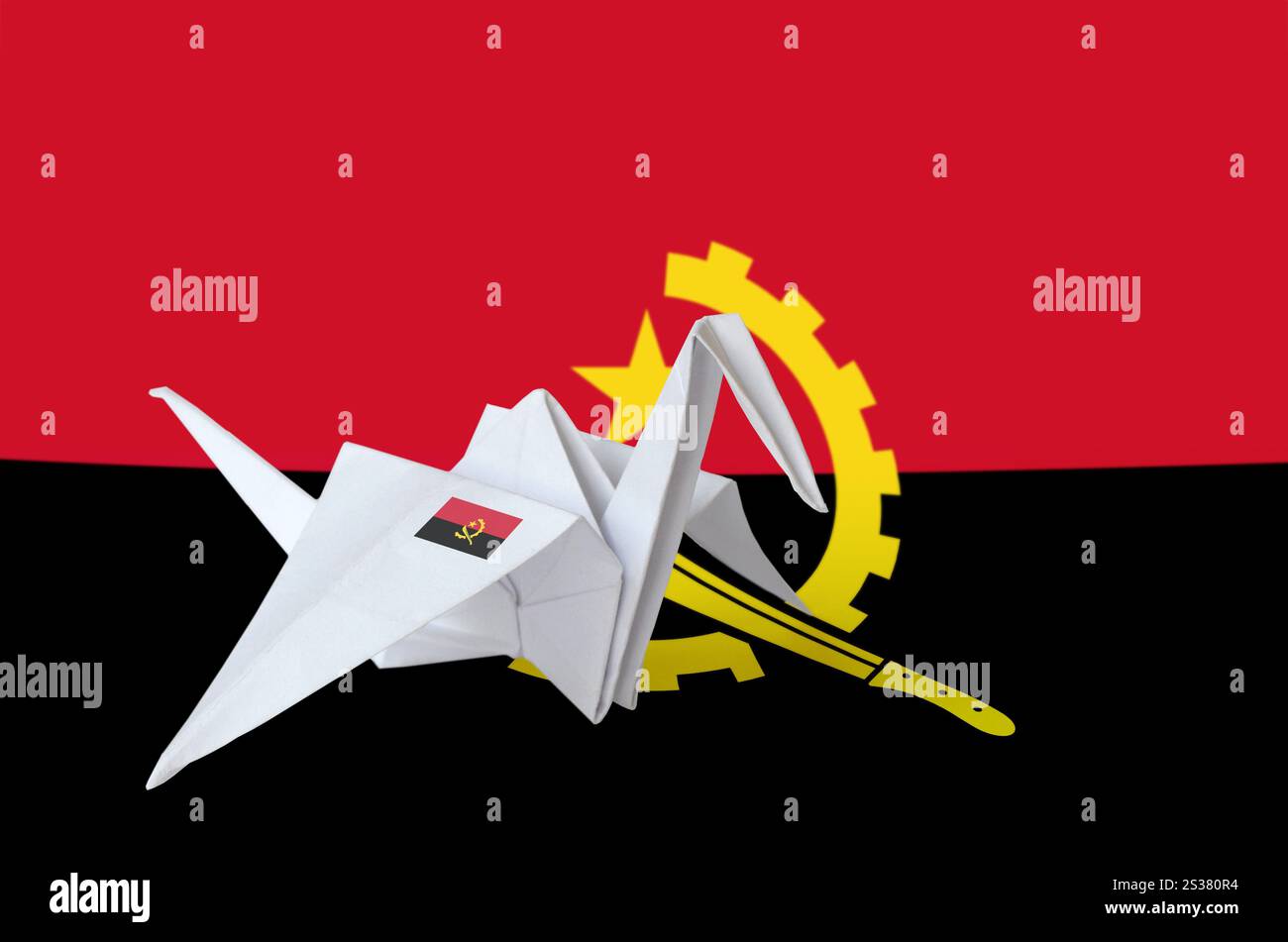Drapeau angolais représenté sur une aile de grue en papier origami. Concept d'arts orientaux faits à la main. Drapeau angolais représenté sur une aile de grue en papier origami. Arts faits main Banque D'Images