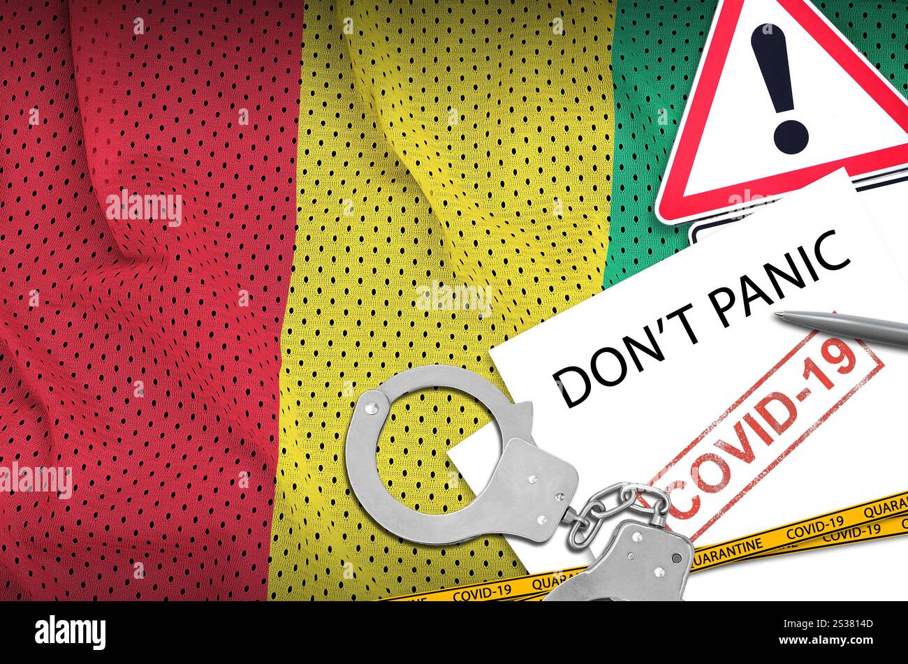 Drapeau de Guinée et menottes de police avec inscription ne paniquez pas sur papier blanc. Concept de coronavirus ou virus pandémique 2019-nCoV. Drapeau guinéen et police Banque D'Images