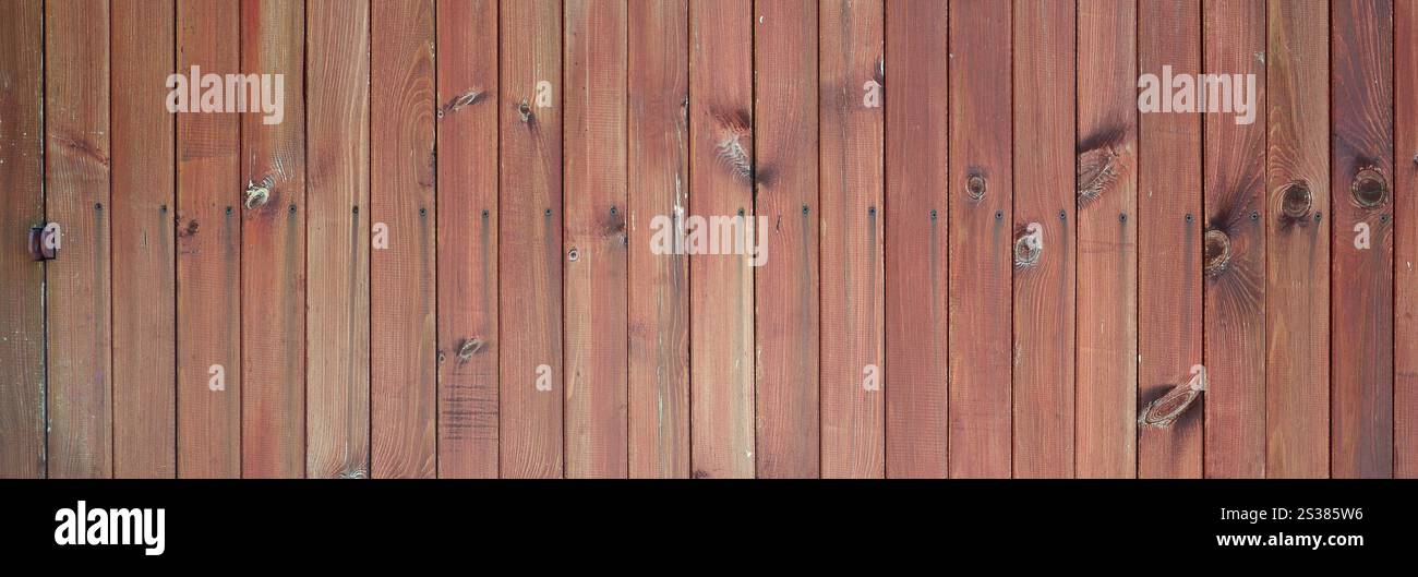 Gros plan de panneaux de clôture en bois brun. Beaucoup de planches de bois verticales comme un mur complet. Gros plan de panneaux de clôture en bois brun. Beaucoup de planches de bois verticales Banque D'Images