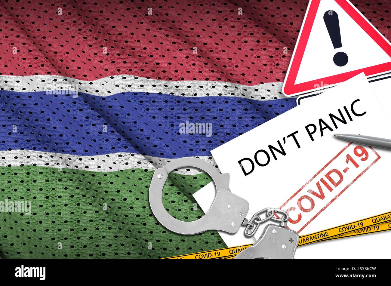 Drapeau de Gambie et menottes de police avec inscription ne paniquez pas sur papier blanc. Concept de coronavirus ou virus pandémique 2019-nCoV. Drapeau gambien et police Banque D'Images